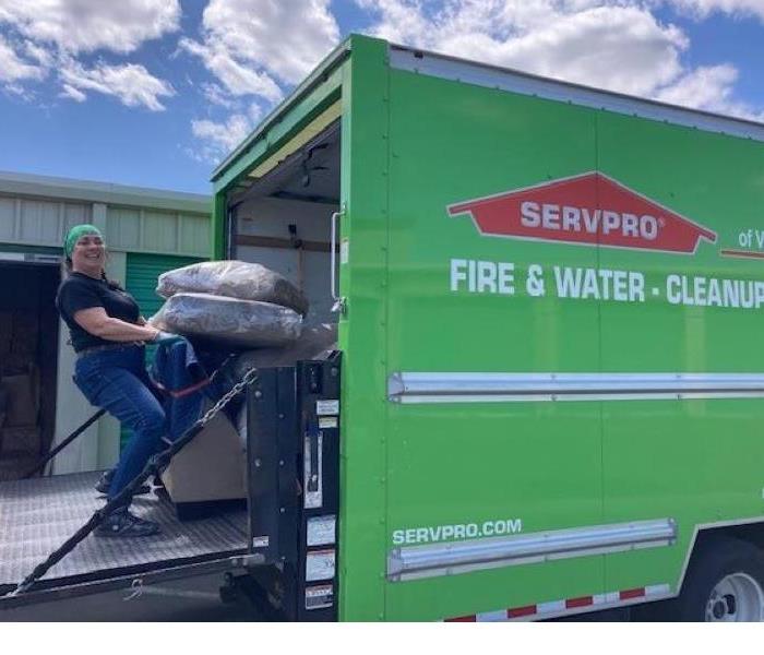 Photo shows employee loading contents into a SERVPRO truck